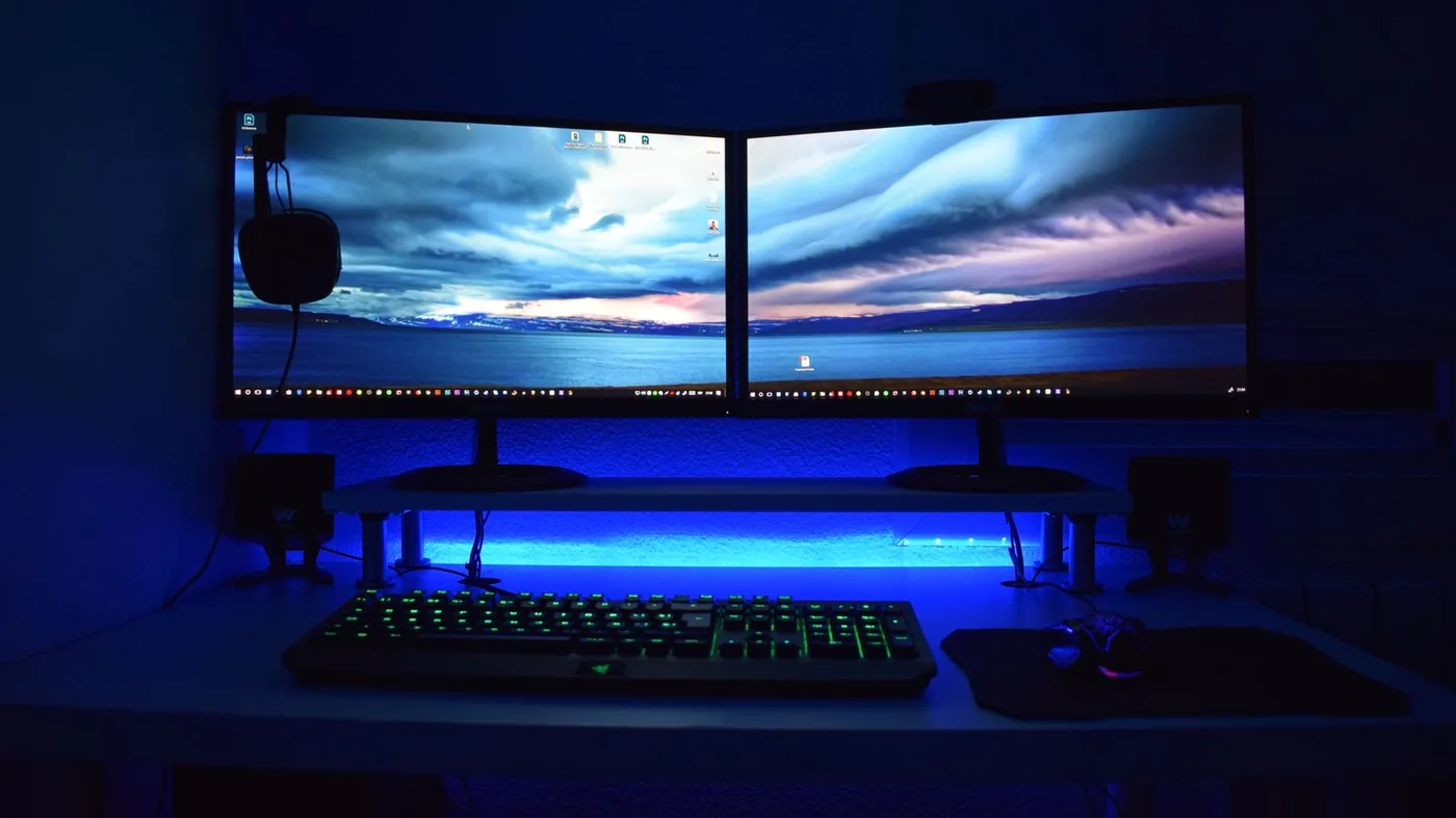 Desk with two monitors, a keyboard and a headset. Not a CS2 screenshot and not the Video menu.